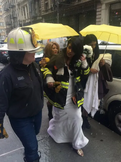 Bride-to-be Nesh Pillay, 25, is assisted by New York City firefighter Chaplain Ann Kansfield after a crane collapsed near the beauty salon where she was having her hair done in downtown Manhattan in New York February 5, 2016. The accident killed at least one person and seriously injured two others, a spokesman for the New York City Fire Department said. (Photo by Gina Cherelus/Reuters)