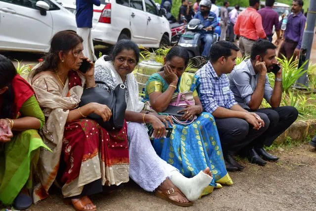 Jehovah's Witness faithful and others wait outside the Zamra International Convention Center after an explosive device blew up during their prayer session in Kalamassery, a town in Kochi, southern Kerala state, India, Sunday, October 29, 2023. At least one person died and 36 others were injured in the explosion, authorities said. (Photo by AP Photo)