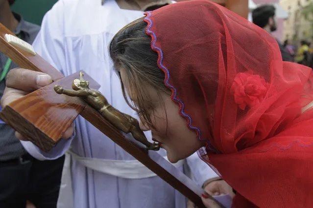 A Pakistani Christian woman kisses a representation of the Christ during a Mass on Good Friday in a church in Lahore, Pakistan, Friday, April 3, 2015. Christians around the world are marking the Easter holy week. (Photo by K. M. Chaudary/AP Photo)