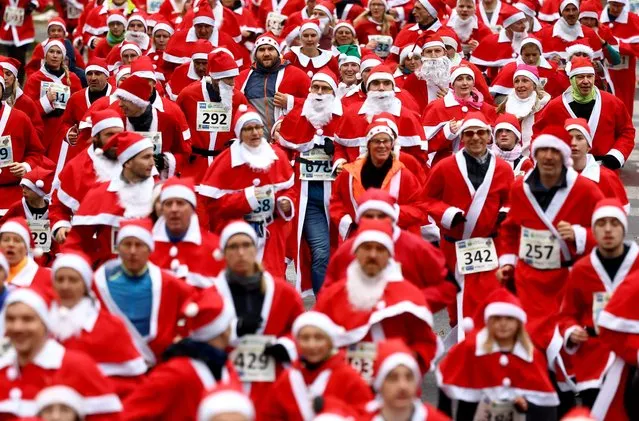 People dressed as Santa Claus run through the streets as they take part in the annual Nikolaus Lauf (Saint Nicholas run), in Michendorf, Germany on December 10, 2023. (Photo by Lisi Niesner/Reuters)