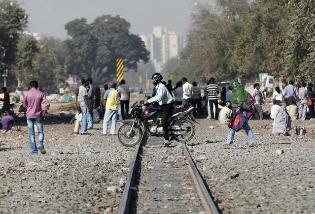 A man riding his motorbike crosses a railway track in Ahmedabad, India, February 24, 2016. (Photo by Amit Dave/Reuters)