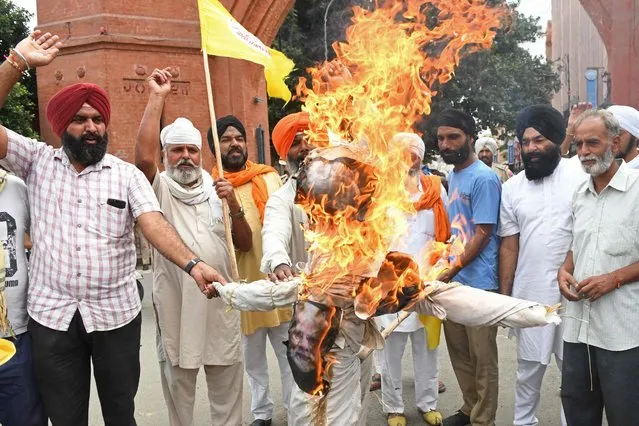 Farmers shout slogans as they burn an effigy of India's Prime Minister Narendra Modi during a protest against the central government's agricultural reforms, in Amritsar on September 17, 2021. (Photo by Narinder Nanu/AFP Photo)