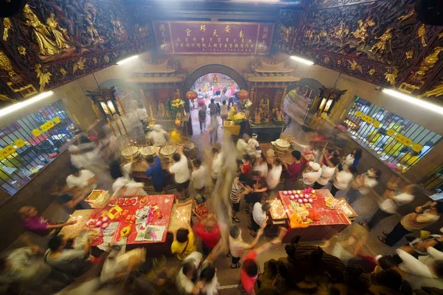 Ethnic Chinese with joss sticks in their hands crowd a temple during the Nine Emperor Gods Festival in Kuala Lumpur, Malaysia, Sunday, October 22, 2023. The festival, held for the first nine days of the ninth month in the Chinese lunar calendar, is a ceremony to welcome the Nine Emperor Gods believed to live in the stars in heaven under the reign of “Thien Hou”, or the Queen of Heaven, who bring good fortune, longevity, and good health. (Photo by Vincent Thian/AP Photo)