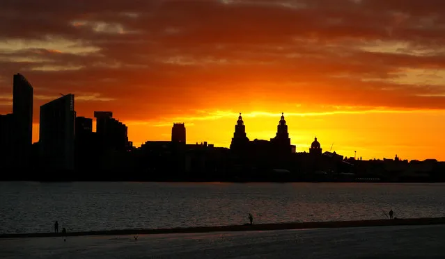 Fishermen line the banks of the River Mersey as the sun rises behind the skyline of Liverpool, northern England December 4, 2016. (Photo by Phil Noble/Reuters)