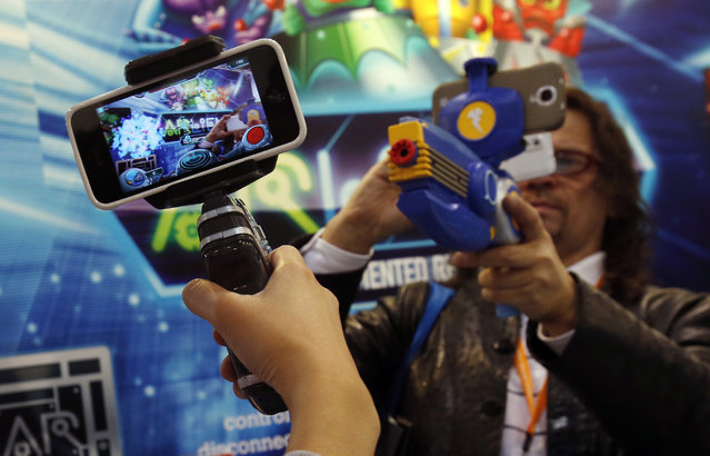 Smartphones are attached to toy guns for a virtual reality shooting game at the Hong Kong Toys and Games Fair January 6, 2014. (Photo by Bobby Yip/Reuters)