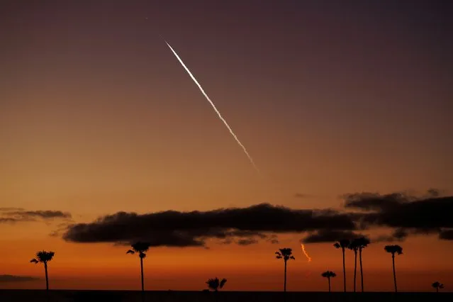 An evening launch of a SpaceX Falcon 9 rocket carrying 22 Starlink satellites to low-Earth orbit from Space Launch Complex 4 East (SLC-4E) at Vandenberg Space Force Base is seen over the Pacific Ocean from Encinitas, California, U.S., April 1, 2024. (Photo by Mike Blake/Reuters)