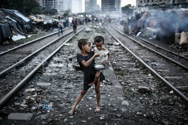 “This photo was taken at Kawranbazar slum in Dhaka, where people live along with two rail tracks on both of the sides and when there is no train, this rail tracks become their common space”. (Photo and caption by Turjoy Chowdhury/2014 Sony World Photography Awards)