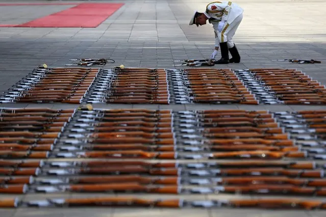 A member of the People's Liberation Army honor guards arranges the guns before a welcome ceremony for Swiss President Schneider-Amman (not pictured) at the Great Hall of the People in Beijing, China, 08 April 2016. The Swiss official is on an official visit and is expected to meet with Chinese counterparts to boost bilateral ties. (Photo by Wu Hong/EPA)