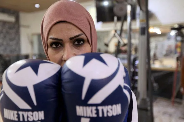 Bushra Abdul Zahra, a 36-year-old Iraqi local boxing and karate practitioner, poses for the camera at a gym in Najaf, Iraq on December 24, 2021. (Photo by Alaa Al-Marjani/Reuters)