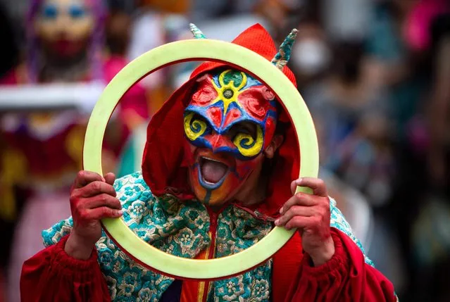 A person in a devil costume takes part in an annual parade of allegorical cars to celebrate New Year's Eve through the main streets of Quito, on December 31, 2021. (Photo by Cristina Vega Rhor/AFP Photo)