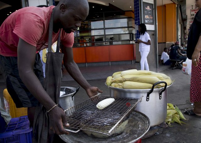 A trader sells mealies to a commuter in Durban, South Africa, April 19, 2016, as food prices continue to rise due to drought conditions. (Photo by Rogan Ward/Reuters)