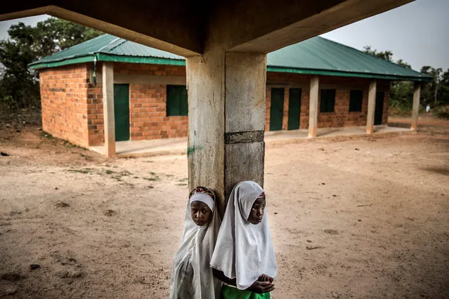 Two Fulani girls gather outside a classroom prior to the beginning of the day's lessons at Wuro Fulbe Nomadic School in Kacha Grazing Reserve for Fulani people, Kaduna State, Nigeria, on April 19, 2019. The National Commission for Nomadic Education and National Nomadic Education Programme were created to ensure equal access to basic education by nomadic and semi nomadic populations in Nigeria. Nowadays, due to the lack of resources of this national program, classes are overcrowded with students. (Photo by Luis Tato/AFP Photo)