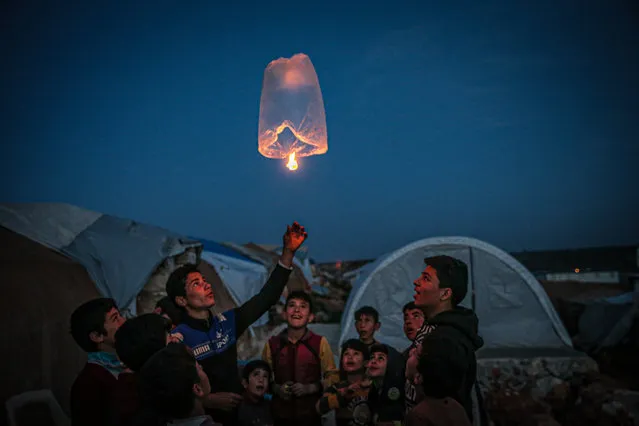 Syrian children living in makeshift tents light sky lanterns as the civil war in Syria enters its 11th year in Betinte village of Idlib, Syria on March 11, 2021. During the war almost half of Syrias total population left their homes and one out of four left Syria. Ten years have passed since Assad regime forces responded to peaceful demonstrations by the Syrian people seeking democracy, justice, rights and freedom. (Photo by Muhammed Said/Anadolu Agency via Getty Images)