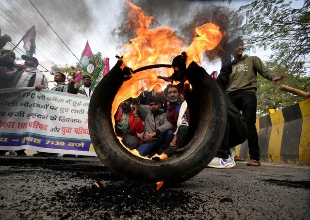 Activists from Jan Adhikar Party burn tyres as they block a road during a strike called by student associations to protest against what they call irregularities in recruitment by the railways department, in Patna, Bihar, India, January 28, 2022. (Photo by Reuters/Stringer)