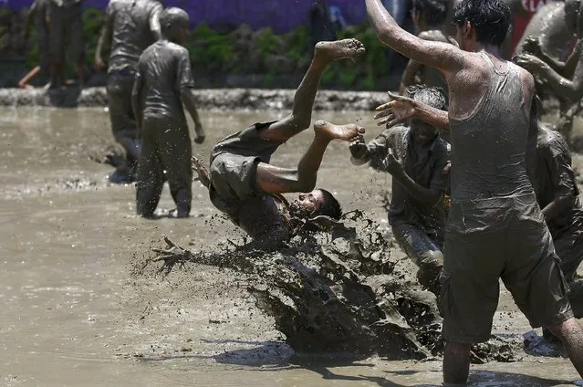 A boy is tossed on the mud during the Asar Pandhra festival in Pokhara valley, west of Nepal's capital Kathmandu, June 30, 2015. (Photo by Navesh Chitrakar/Reuters)