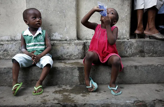 Nigerian children sit outside a polling station in the neighbourhood of Isale-Eko in central Lagos, April 14, 2007. Nigerians went to the polls on Saturday to choose state governors in the first of two elections which should lead to the first fully democratic transition in Africa's most populous nation and top oil producer. (Photo by Finbarr O'Reilly/Reuters)