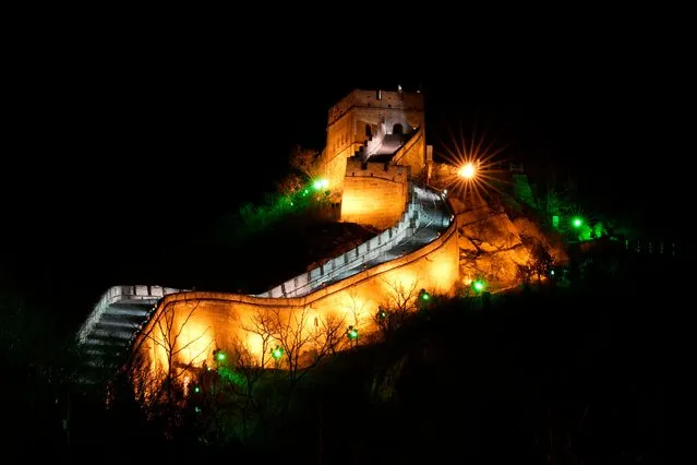 The Badaling section of the Great Wall of China is lit on the outskirts of Beijing on Tuesday, February 8, 2022, in Beijing. (Photo by Ng Han Guan/AP Photo)