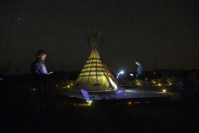 In this March 27, 2017 photo, Associated Press team, writer Christopher Sherman, right, and photographer Rodrigo Abd, stand next to their tipi-style tent lodging at Tin Valley Retro Rentals in Terlingua, Texas, near the US-Mexico border. The AP has sent the team on a nearly two-week journey, from west to east along the entire length of the US-Mexico, to bring us fresh voices and images from both sides of these vast and varied borderlands and see what is happening on the ground. (Photo by Rodrigo Abd/AP Photo)