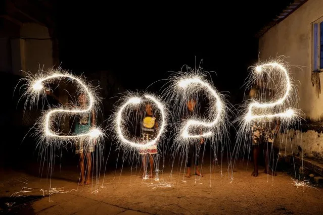 A slow shutter speed picture showing Sri Lankan children's writing «2022» with firecrackers during New Year's celebrations in Colombo, Sri​ Lanka, 31 December 2021. (Photo by Chamila Karunarathne/EPA/EFE)