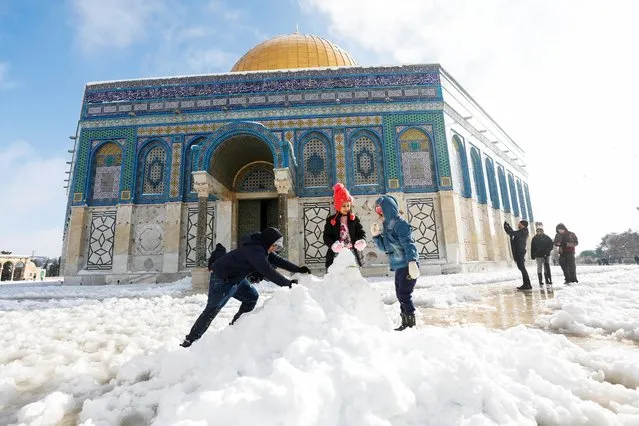Children build a snowman in front of the Dome of the Rock, located in Jerusalem's Old City on the compound known to Muslims as Noble Sanctuary and to Jews as Temple Mount during a snowy morning in Jerusalem's Old City, January 27, 2022. (Photo by Ammar Awad/Reuters)