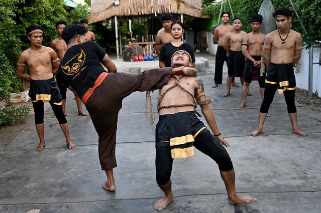 This photo taken on May 25, 2024 shows ancient Khmer martial art Yutkromkhorm master Nak Rinda (2nd L) showing a fighting technique with his student during a training session at his club in Krong Areyksat. The ancient Khmer combat martial art of Yutkromkhorm was largely forgotten after many of its masters were killed in a purge of intellectuals under the communist Khmer Rouge between 1975 and 1979, but a group of young Cambodians are determined to learn its techniques and keep their heritage alive. (Photo by Tang Chhin Sothy/AFP Photo)