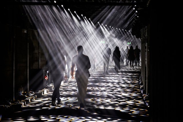 People view an installation of projections and lights called “Dark Spectrum” located at old tram tunnels as part of the annual Vivid Sydney festival in Sydney on May 24, 2024. (Photo by David Gray/AFP Photo)