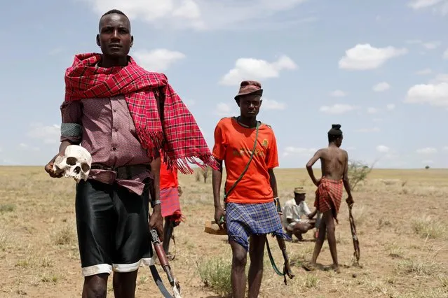 A Turkana warrior poses for a photograph as he holds the scull of a Nyangatom warrior who, according to Turkana warriors, was killed when he and other Nyangatom warriors attacked a group of Turkana people to take their cattle in Ilemi Triangle, Kenya, July 15, 2019. (Photo by Goran Tomasevic/Reuters)