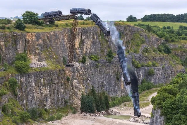 A replica steam train plunges into a quarry near the village of Stoney Middleton in Derbyshire on August 19, 2021 for an action sequence being filmed for “Mission: Impossible 7”. The film’s star, Tom Cruise, arrived in his personal helicopter to watch the stunt. (Photo by John Finney/WENN)