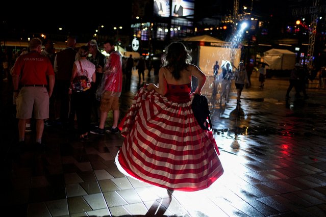 A delegate walks in the rain during Day 1 of the RNC at the Fiserv Forum in Milwaukee, Wisconsin on July 15, 2024. (Photo by Cheney Orr/Reuters)