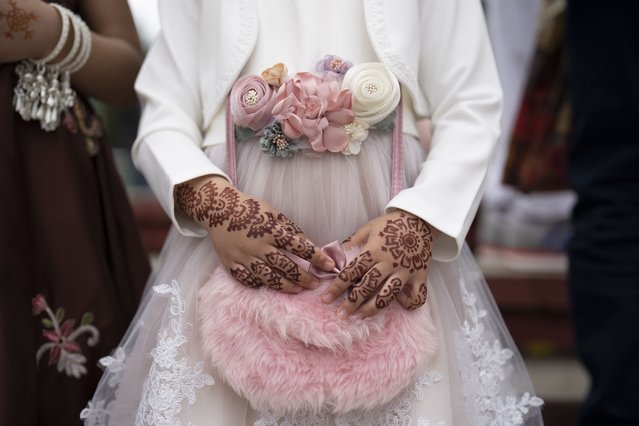 Hafsa Ahmend, 2 years-old, poses for a portrait after Eid Al-Fitr prayers in Bucharest, Romania, Friday, April 21, 2023. Members of the Romanian Muslim community gathered for Eid al-Fitr prayers, marking the end of the holy fasting month of Ramadan, at the Dinamo stadium in the Romanian capital, in the largest Muslim public gathering of the year in Romania. (Photo by Vadim Ghirda/AP Photo)