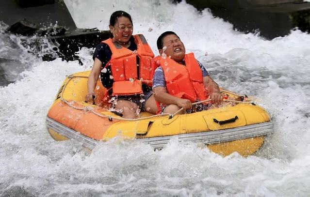 Tourists reacts during white water rafting inside a creek at a resort in Xiuning county, Anhui province, China, July 18, 2015. (Photo by Reuters/Stringer)