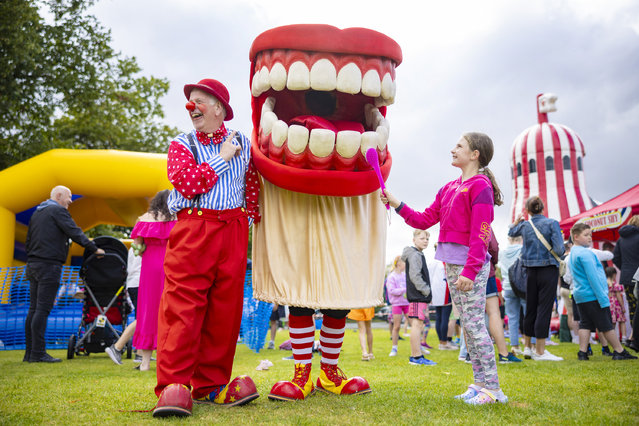 Nine-year-old Faith Sweeney helps brush some giant teeth as the National Festival Circus joins Thirsk Racecourse’s family fun day in North Yorkshire on August 8, 2024. (Photo by James Glossop/The Times)