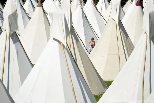 A reveller walks among the tipi tents at the Glastonbury Festival of Music and Performing Arts on Worthy Farm near the village of Pilton in Somerset, South West England, on June 21, 2017. (Photo by Oli Scarff/AFP Photo)