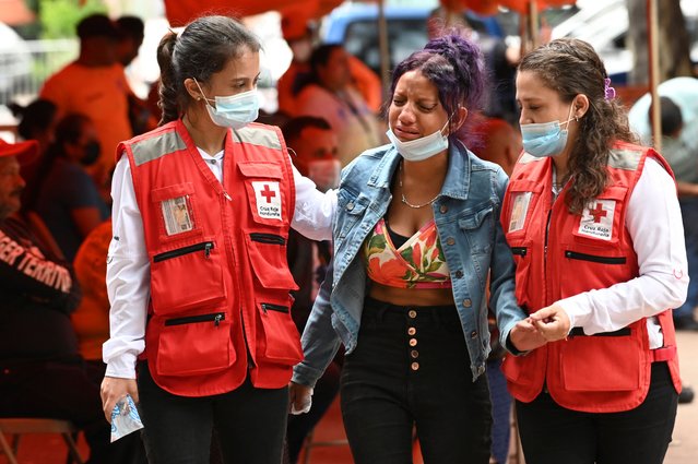 Members of the Honduran Red Cross provide psychological help to a relative of one of the 46 dead women during a fire following a brawl between inmates of the Women's Social Adaptation Center (CEFAS) prison, outside the Legal Medicine and Forensic Science Center in Tegucigalpa on June 21, 2023. The death toll from a fire and violent clashes between rival gangs at a women's prison in Honduras has risen to 46, the prosecutor's office said Wednesday, raising the official count from 41. (Photo by Orlando Sierra/AFP Photo)