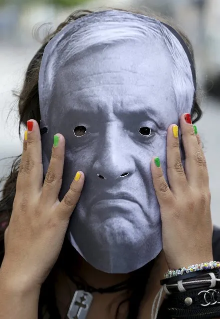 A woman wearing a paper mask with the image of Guatemala's President Otto Perez Molina takes part in a protest to demand the resignation of Guatemala's President, outside of the City Congress in Guatemala City August 8, 2015. (Photo by Jorge Dan Lopez/Reuters)