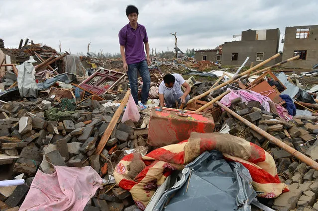 Residents look for belongings in the rubble of a destroyed home in Funing county in Yancheng city in eastern China's Jiangsu Province Friday, June 24, 2016. A tornado and hailstorm struck a densely populated area of farms and factories on the outskirts of an eastern Chinese city on Thursday, killing dozens of people and destroying buildings, smashing trees and flipping vehicles on their roofs. (Photo by Chinatopix via AP Photo)