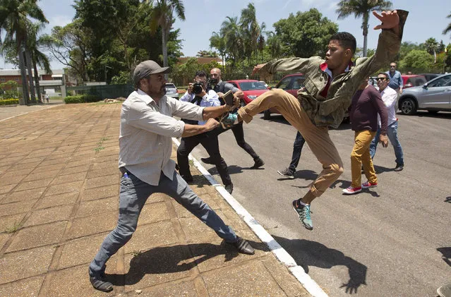 Supporters of Venezuelan President Nicolas Maduro and followers of Juan Guaido, head of the National Assembly, clash outside of the Venezuela's embassy facilities, in Brasilia, Brazil, 13 November 2019. Earlier some supporters of Juan Guaido, head of the National Assembly of Venezuela and self-proclaimed President-in -charge, break into the Venezuelan Embassy in Brasilia with the intention of taking over. (Photo by Joedson Alves/EPA/EFE)