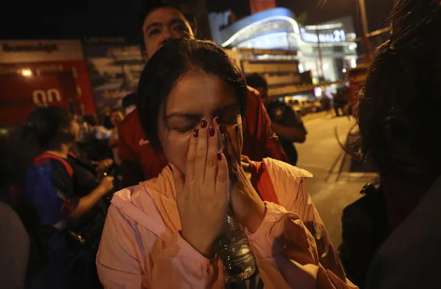 A woman who was able to get out of Terminal 21 Korat mall gestures with her hands on her face in Nakhon Ratchasima, Thailand on Sunday, February 9, 2020. (Photo by Sakchai Lalitkanjanakul/AP Photo)