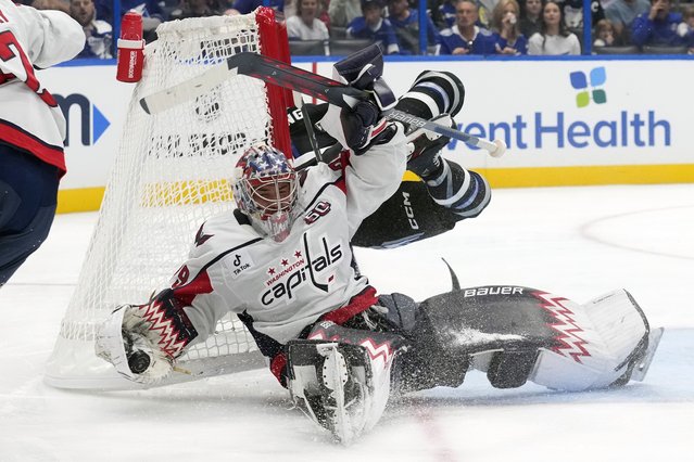 Washington Capitals goaltender Charlie Lindgren (79) makes a save as he gets knocked over by Tampa Bay Lightning center Luke Glendening during the second period of an NHL hockey game Saturday, October 26, 2024, in Tampa, Fla. (Photo by Chris O'Meara/AP Photo)