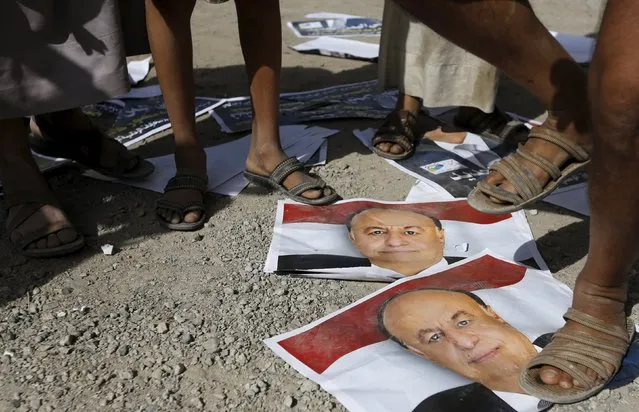 Houthi militants step on posters of Yemen's exiled President Abd-Rabbu Mansour Hadi in front the offices of the education ministry's workers union, destroyed by Saudi-led air strikes, in Yemen's northwestern city of Amran August 19, 2015. (Photo by Khaled Abdullah/Reuters)