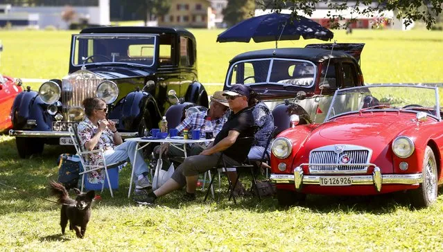 Participants enjoy a picnic during the British Car Meeting 2015 in the village of Mollis, east of Zurich, August 30, 2015. (Photo by Arnd Wiegmann/Reuters)