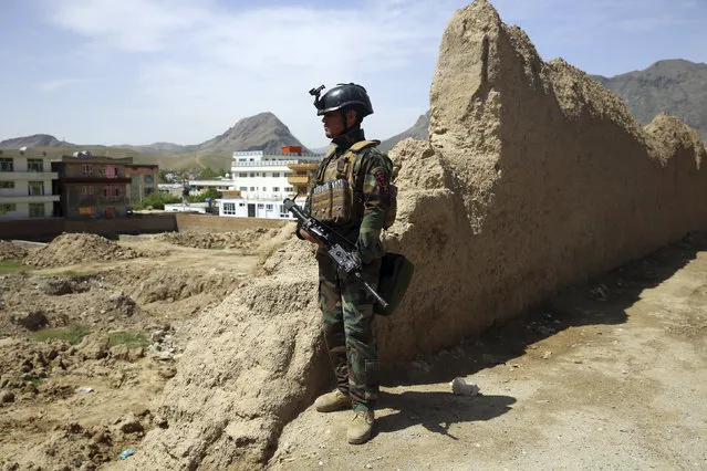 An Afghan special force member stands guard at the site of a suicide bomber attack on the outskirts of Kabul, Afghanistan, Wednesday, April 29, 2020. A suicide bomber on Wednesday targeted a base belonging to Afghan special forces on the southern outskirts of the capital, officials said. (Photo by Rahmat Gul/AP Photo)