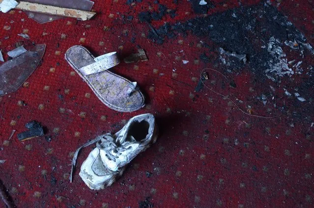 Abandoned shoes remain at the site of a fire inside the Abu Sefein Coptic church that killed at least 40 people and injured some 14 others, in the densely populated neighborhood of Imbaba, Cairo Egypt, Sunday, August 14, 2022. The church said the fire broke out while a service was underway. The cause of the blaze was not immediately known, but an initial investigation pointed to an electrical short-circuit, according to a police statement. (Photo by Tarek Wajeh/AP Photo)