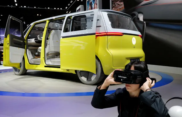 A visitor uses virtual reality device next to Volkswagen's concept I.D. Buzz during media preview of the 45th Tokyo Motor Show in Tokyo, Japan on October 25, 2017. (Photo by Kim Kyung-Hoon/Reuters)