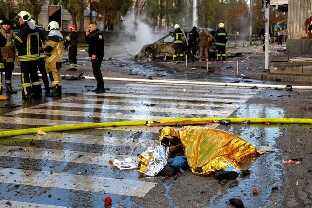 Covered body is seen at the site of missile strike downtown Kyiv, Ukraine, October 10, 2022. Ukrainian officials report that at least eight people were killed and 24 wounded in the Ukrainian capital. (Photo by Valentyn Ogirenko/Reuters)