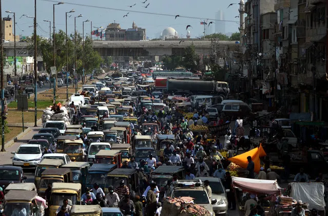 Commuters make their way along a busy road after the government eased the nationwide lockdown imposed as a preventive measure against the COVID-19 coronavirus, in Karachi on May 11, 2020. (Photo by Rizwan Tabassum/AFP Photo)