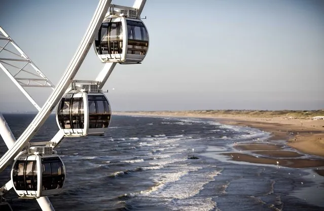 A photo made available on 19 August 2016 of cabins of the Scheveningen Pier Ferris Wheel overlooking the Scheveningen beach, near The Hague, The Netherlands, 18 August 2016. The 36-cabin Ferris Wheel with a height of about 50 meters is the latest attraction at the beach and was finished earlier this summer. (Photo by Freek Van Den Bergh/EPA)