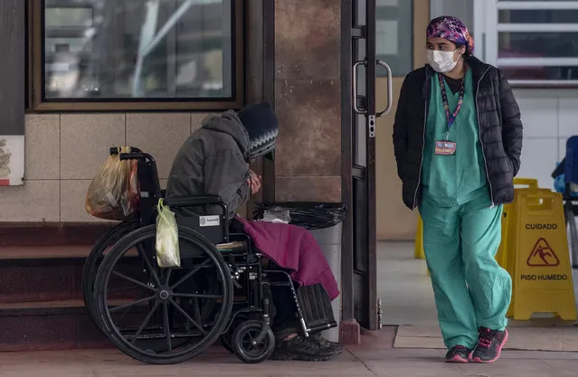 A homeless awaits outside the emergency area of the San Jose Hospital, in Santiago, on June 18, 2020, amid the novel coronavirus pandemic. Chile exceeded 225,000 infections and 3,841 deaths due to coronavirus, being as one of the countries most affected by the pandemic, while reinforcing the quarantine that affects nearly half of its 18 million inhabitants. (Photo by Martin Bernetti/AFP Photo)