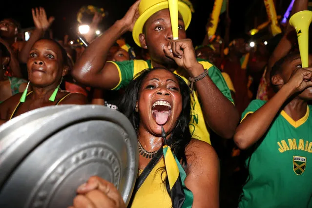 Fans cheer while watching a broadcast of Jamaica's Usain Bolt winning the men's 100 meters final and becoming the first man to win three successive Olympic titles on the track, in Kingston, Jamaica, August 14, 2016. (Photo by Gilbert Bellamy/Reuters)