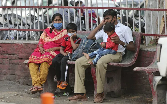 Indians wearing masks wait for transport outside a hospital in Jammu, India, Tuesday, June 23, 2020. India has been recording about 15,000 new infections each day, and some states Tuesday were considering fresh lockdown measures to try to halt the spread of the virus in the nation of more than 1.3 billion. (Photo by Channi Anand/AP Photo)